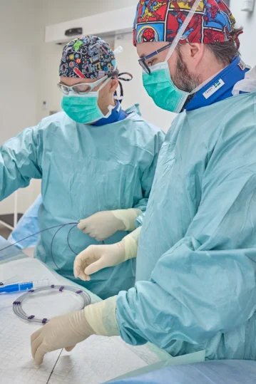 Lekarze Cezary Szary i Michał Zawadzki przeprowadzający embolizację malformacji żylnych w pracowni naczyniowej Kliniki Flebologii. Specjalistyczne zabiegi w leczeniu niewydolności żylnej i malformacji naczyniowych.