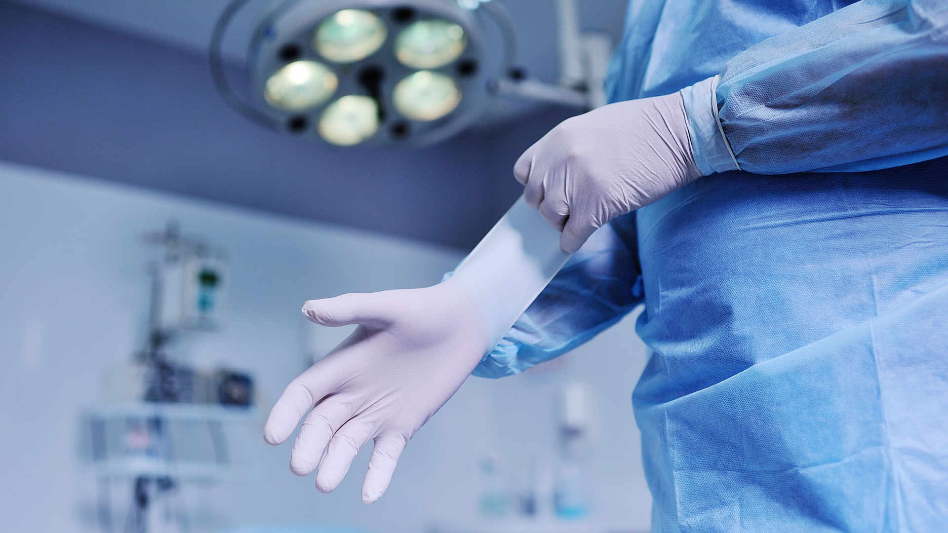 Proktolog zakłada rękawiczki przed zabiegiem.